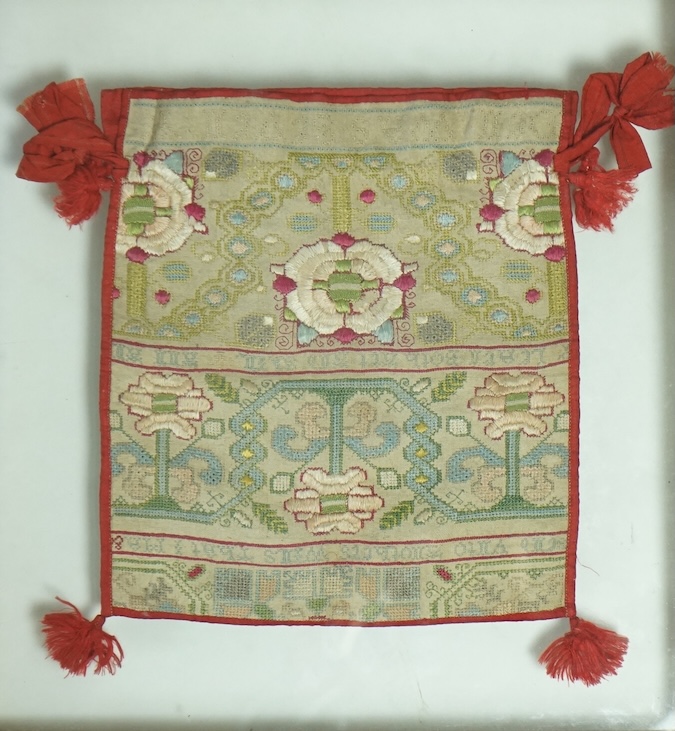 A 18th century long cross stitch sampler, converted later in the early 19th century into a bible bag and then later framed. The sampler worked in rows of alternate religious verse and floral embroidery. The sampler then